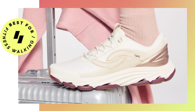 Woman wearing white sneakers posing with a suitcase