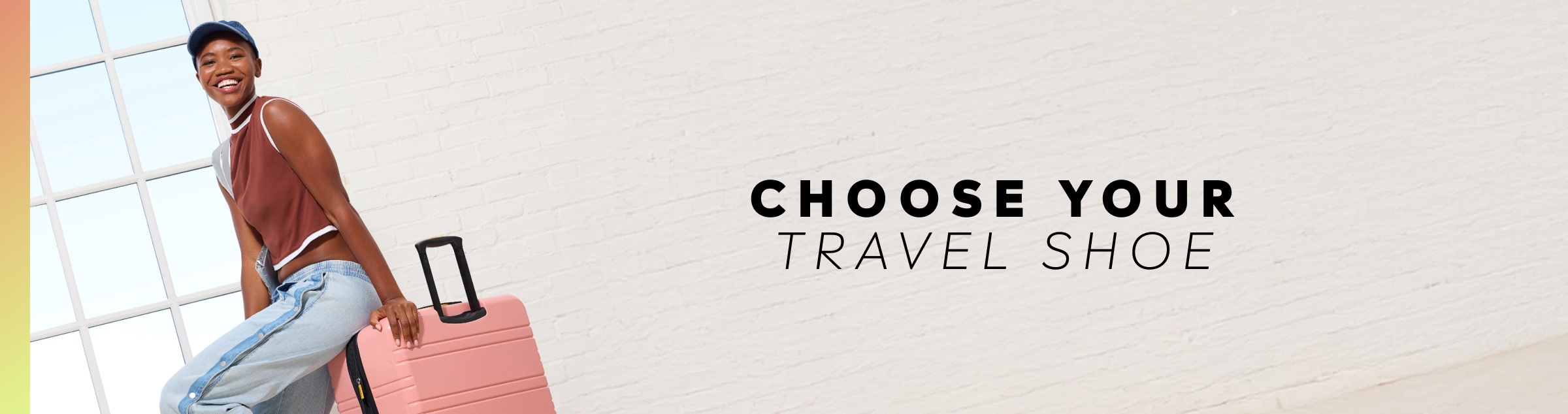 A woman wearing a brown top, jeans, and a hat, sitting on a pink suitcase with text reading 