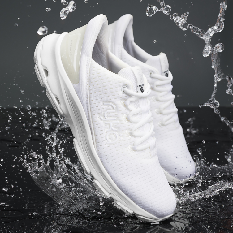 A pair of white Rykä Stain Protectant Devotion sneaker shoes splashing water