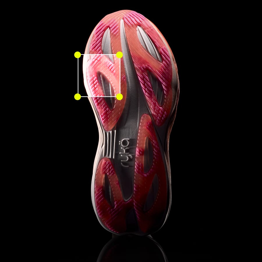 A pink sole of women's running sneaker on a black background with a square at the toe highlighting the texture.  