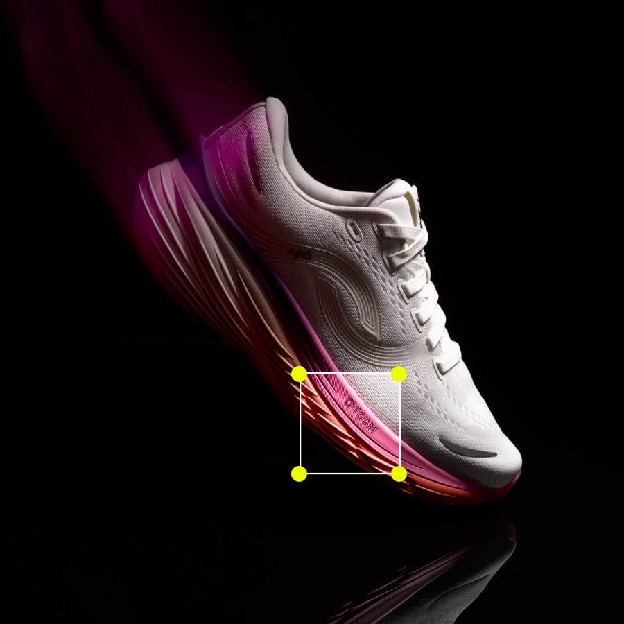 Pink and white women's running sneaker on a black background with a square at the sole highlighting the Q Foam technology. 