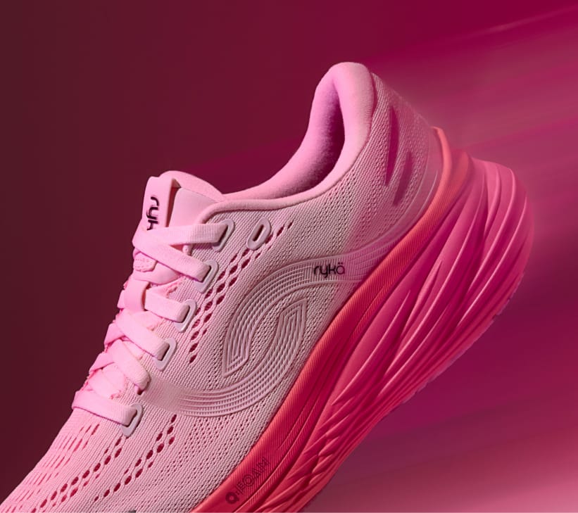 A pink women's running sneaker with a bright pink sole displayed at an angle on a dark pink background. 