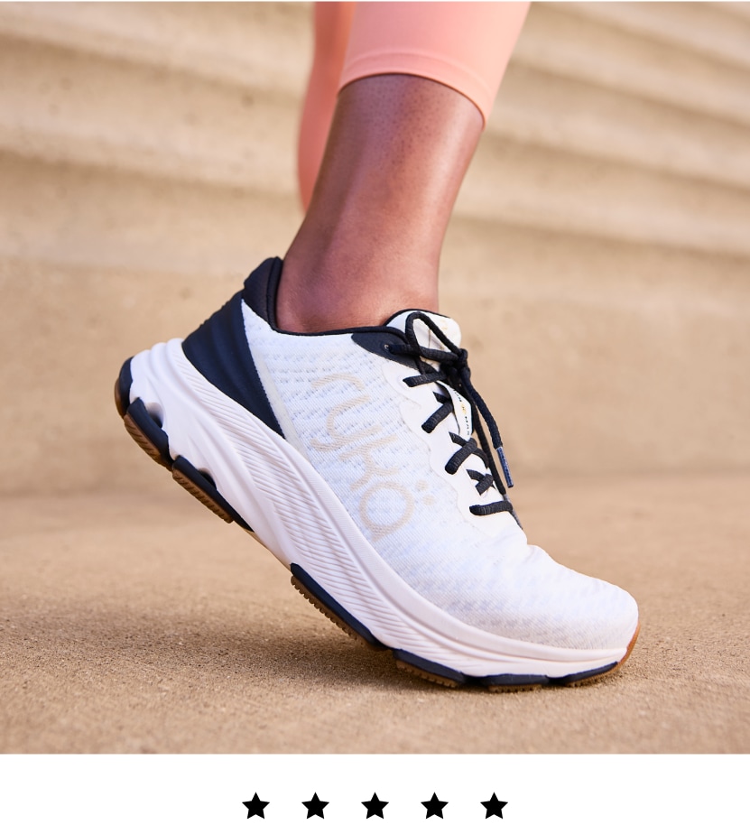 A model wearing a black and white Rykä Devotion X Max RS shoe