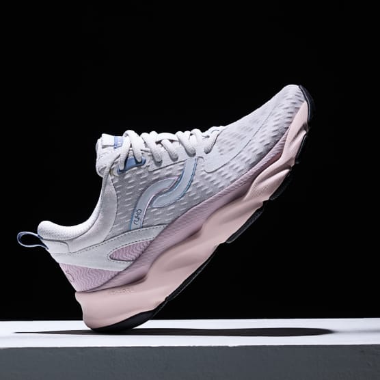 Women's gray sneaker with a pink sole displayed at an angle on a black background.