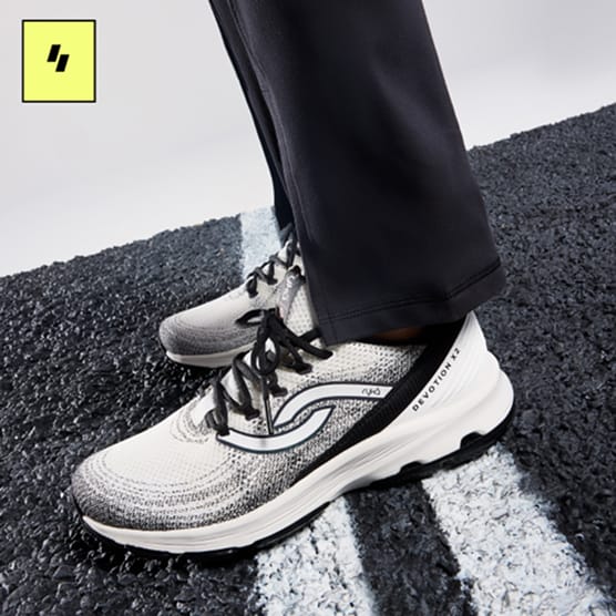Pair of black and white women's sneakers on a running track. 