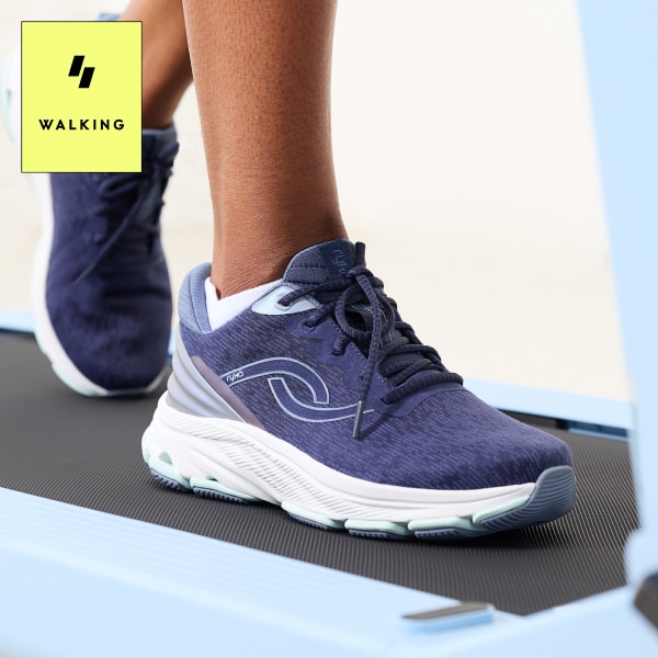 A woman walking on a treadmill wearing a pair of blue sneakers with a white sole. A yellow graphic with the word 